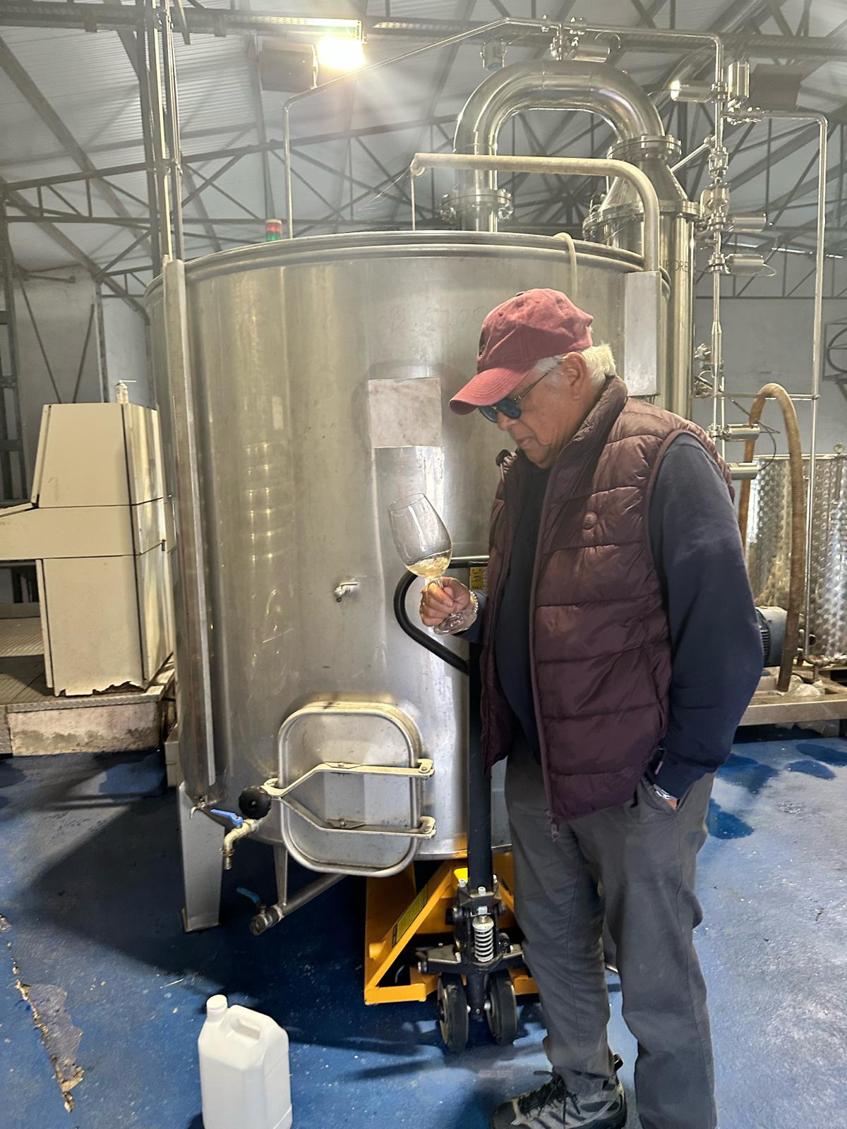 Person standing next to a large metal tank in an industrial setting