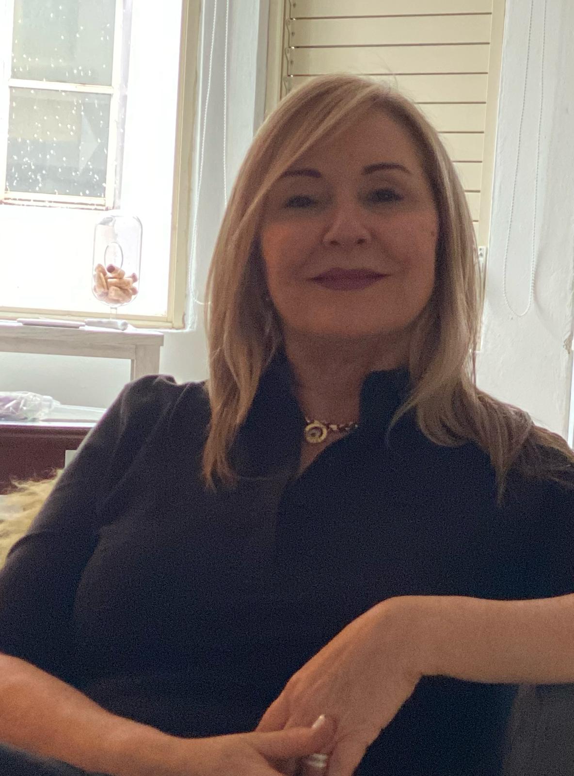 Woman sitting indoors with a window in the background